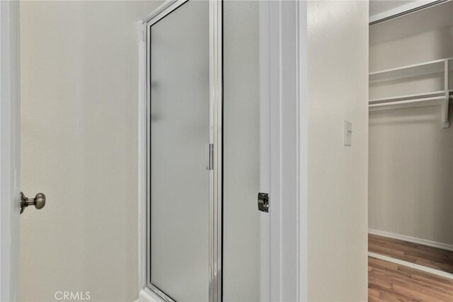 766 Harper St, Simi Valley, CA 93065 - bathroom with a stall shower, a walk in closet, wood finished floors, and baseboards