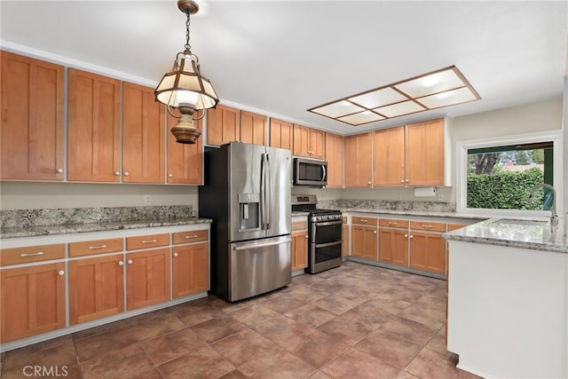 kitchen featuring a sink, appliances with stainless steel finishes, decorative light fixtures, and light stone countertops