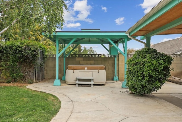 view of patio / terrace with a hot tub, a gazebo, and fence