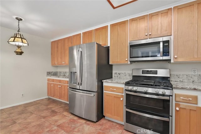 kitchen with baseboards, pendant lighting, appliances with stainless steel finishes, and light stone counters