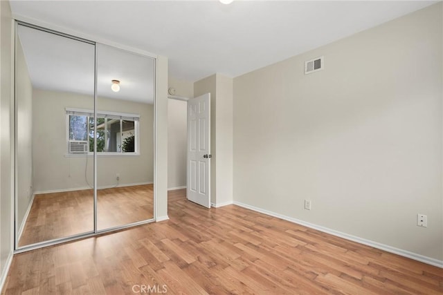 unfurnished bedroom with baseboards, light wood-style flooring, and visible vents