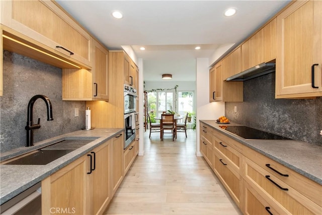 kitchen featuring a sink, stainless steel appliances, light brown cabinetry, and ventilation hood