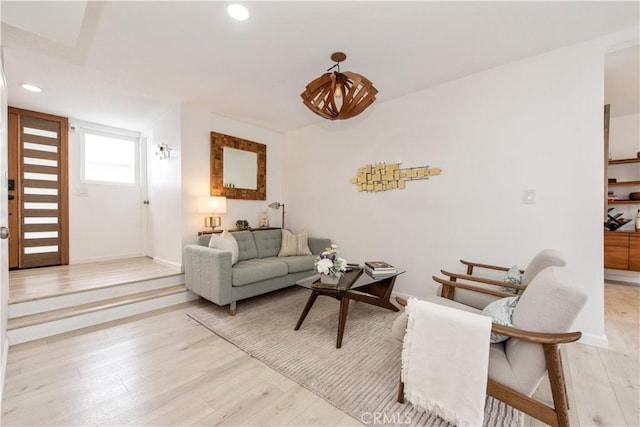 living area featuring light wood finished floors, baseboards, and recessed lighting
