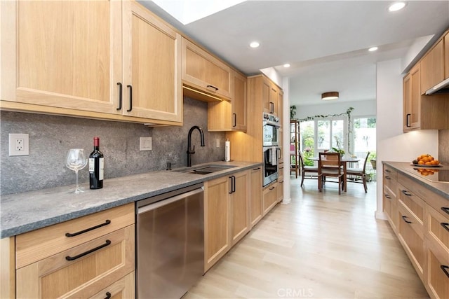 kitchen with light brown cabinets, recessed lighting, light wood finished floors, a sink, and appliances with stainless steel finishes