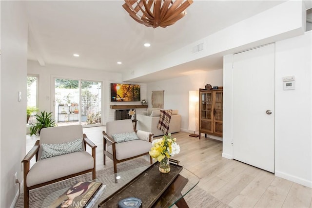 living area with light wood-style floors, visible vents, baseboards, and recessed lighting