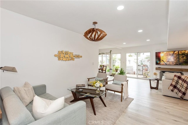 living area with baseboards, light wood-style floors, and recessed lighting