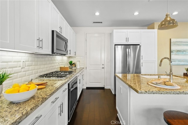 15 Clover, Lake Forest, CA 92630 - kitchen with appliances with stainless steel finishes, white cabinetry, dark wood finished floors, light stone countertops, and recessed lighting