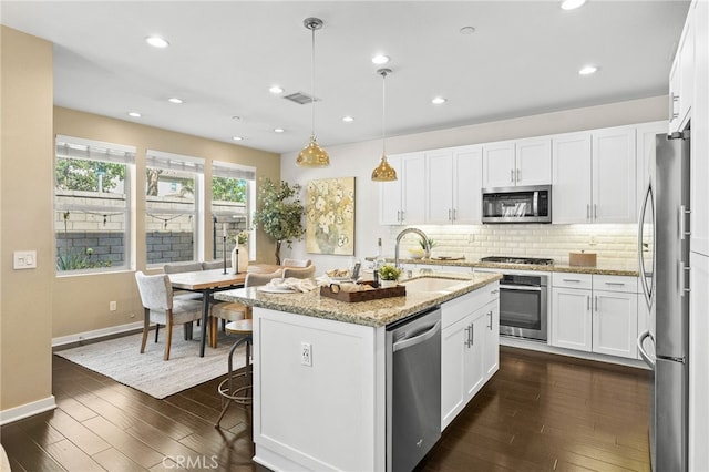 15 Clover, Lake Forest, CA 92630 - kitchen featuring appliances with stainless steel finishes, a sink, dark wood-style flooring, light stone countertops, and white cabinetry