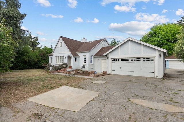 9438 Burnet Ave, North Hills, CA 91343 - view of front of property with an attached garage, stucco siding, driveway, and a chimney