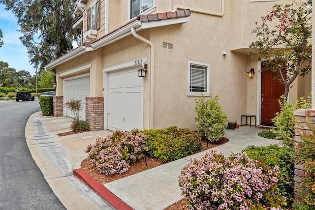 view of property exterior with a garage and stucco siding