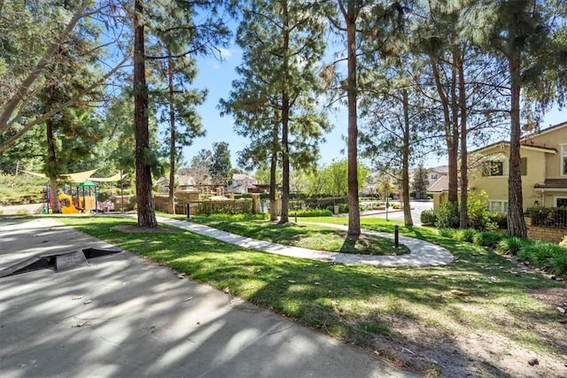 view of property's community with a yard, playground community, and a residential view