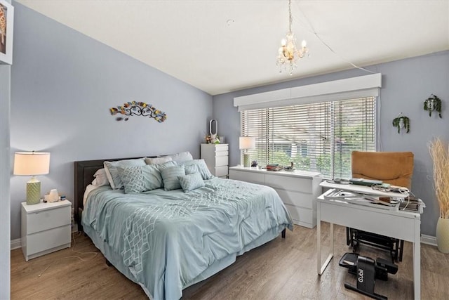 bedroom with light wood-type flooring and a chandelier