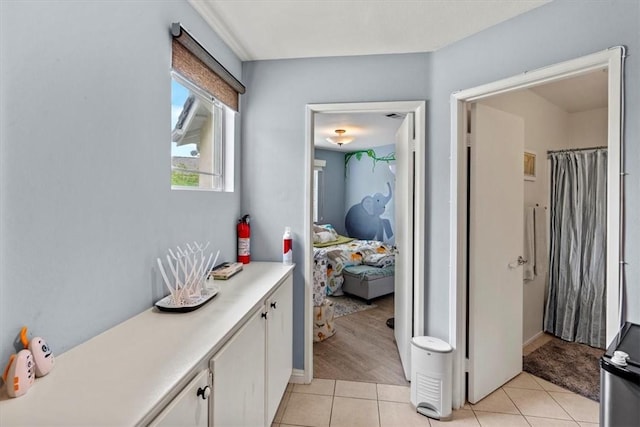 corridor with baseboards and light tile patterned flooring