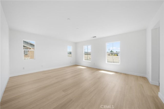 unfurnished room featuring light wood finished floors and baseboards