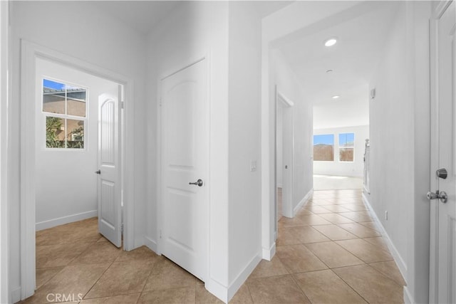 hallway with light tile patterned floors, baseboards, and recessed lighting
