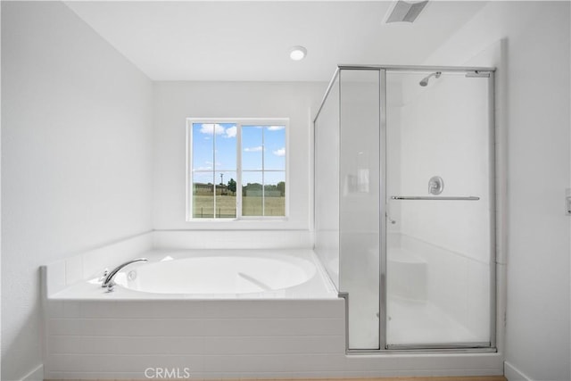 full bathroom featuring a garden tub and a shower stall