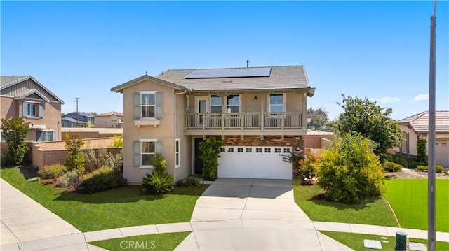 view of front facade with stucco siding, roof mounted solar panels, concrete driveway, and a front yard