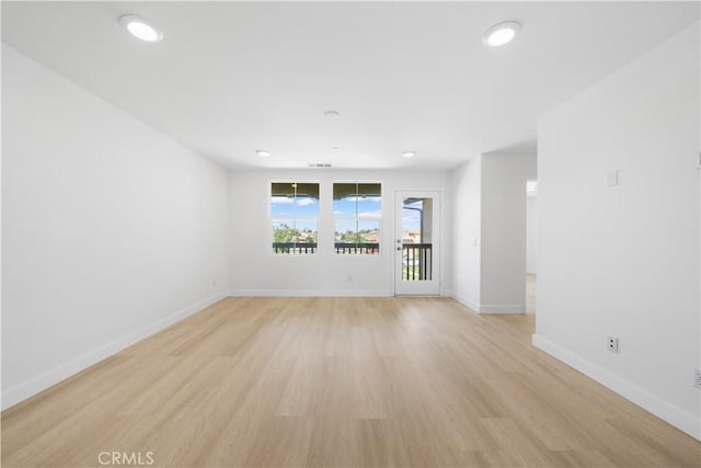 unfurnished room featuring light wood-style flooring, baseboards, and recessed lighting