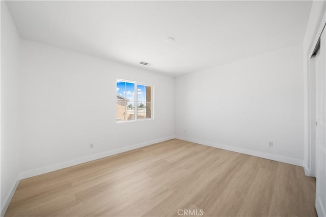 unfurnished bedroom with light wood-style flooring, baseboards, and a closet