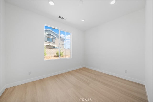 spare room with light wood-type flooring, baseboards, and recessed lighting