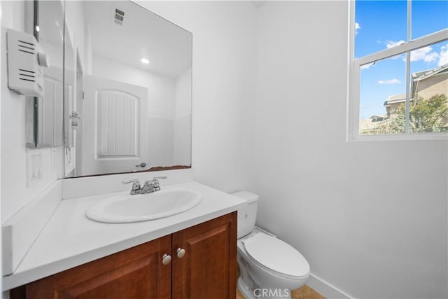 bathroom featuring vanity, toilet, and baseboards