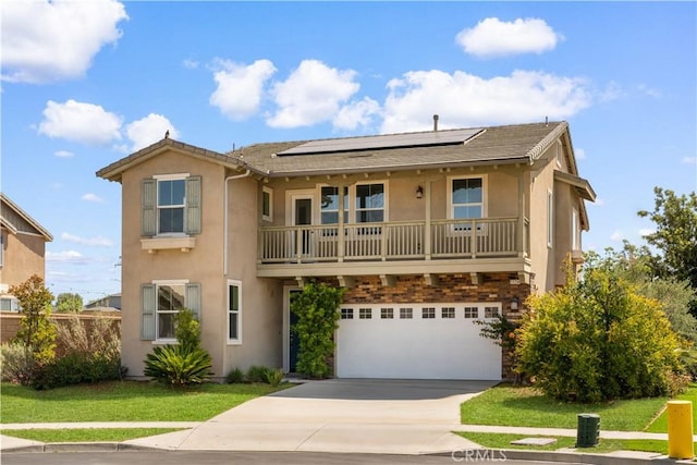 view of front of home featuring stucco siding, driveway, roof mounted solar panels, and a garage