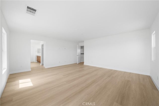 unfurnished living room with light wood-style flooring and baseboards