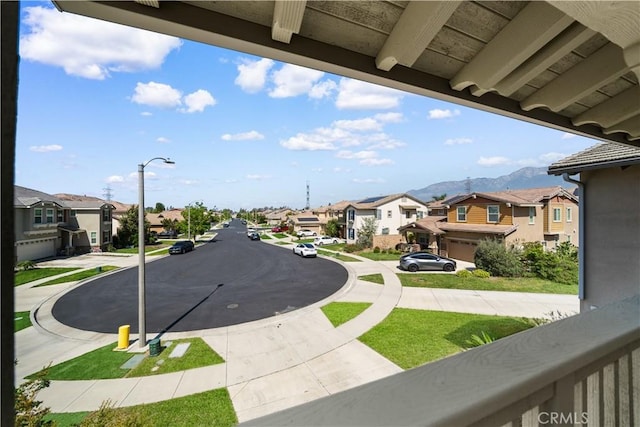 view of asphalt road with a residential view and sidewalks