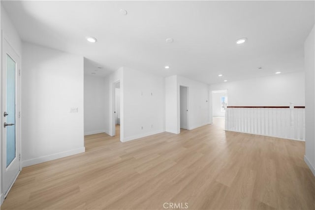unfurnished living room with recessed lighting, light wood-style floors, and baseboards