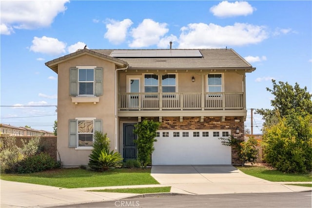 view of front of property featuring stucco siding, driveway, roof mounted solar panels, and an attached garage