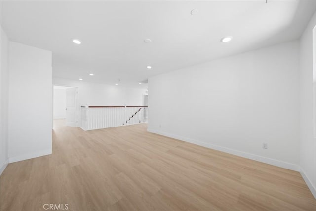 empty room with light wood-style flooring, recessed lighting, and baseboards