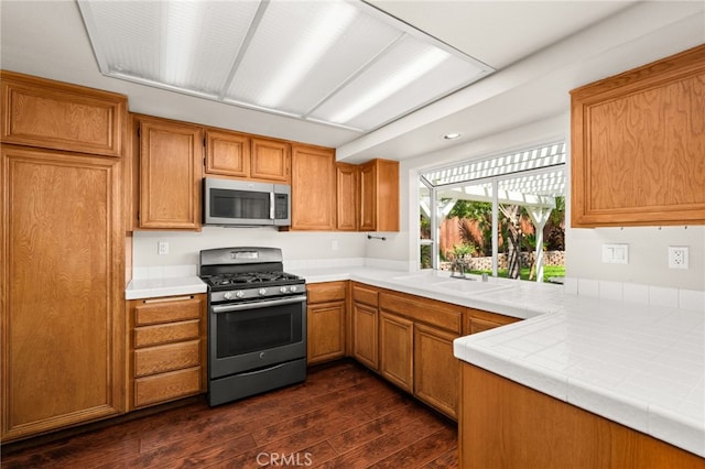 11820 Mount Wilson Ct, Rancho Cucamonga, CA 91737 - kitchen with dark wood-style flooring, tile counters, brown cabinets, a sink, and appliances with stainless steel finishes