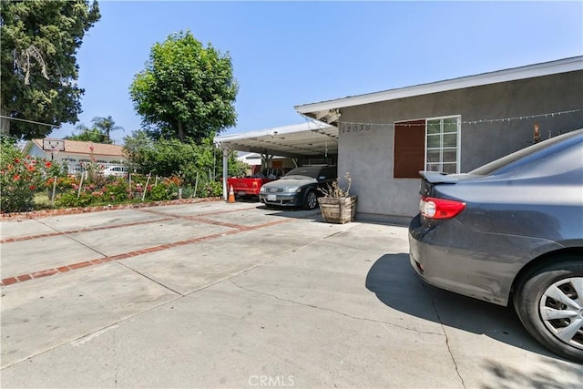 12036 Jouett St, Sylmar, CA 91342 - view of parking / parking lot featuring an attached carport and concrete driveway