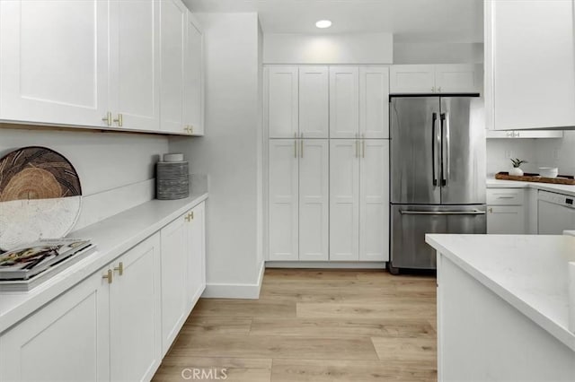 kitchen with freestanding refrigerator, recessed lighting, white cabinets, light wood finished floors, and dishwasher