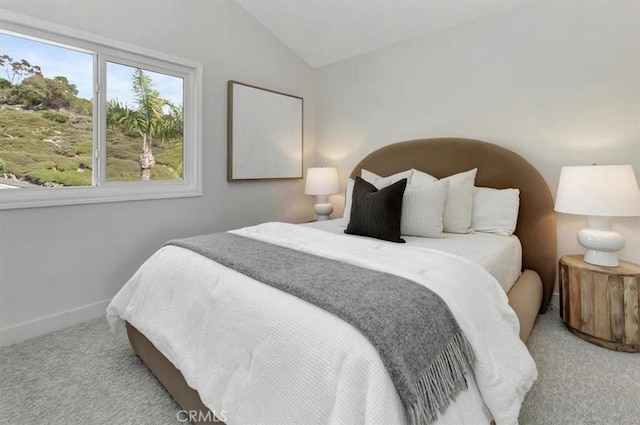 carpeted bedroom with baseboards and lofted ceiling