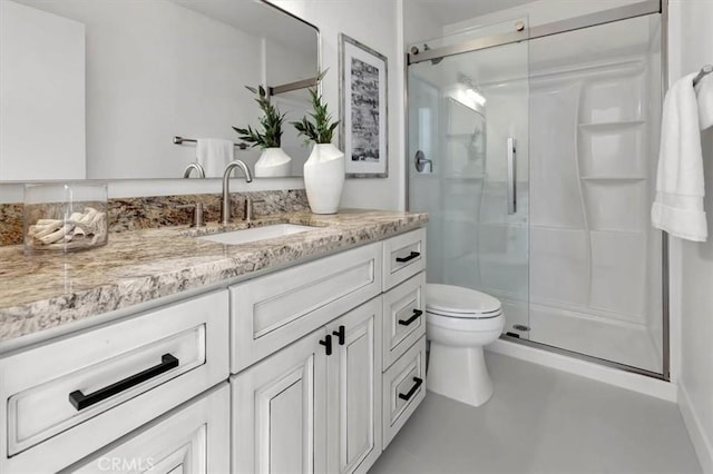 full bathroom featuring vanity, a stall shower, and toilet