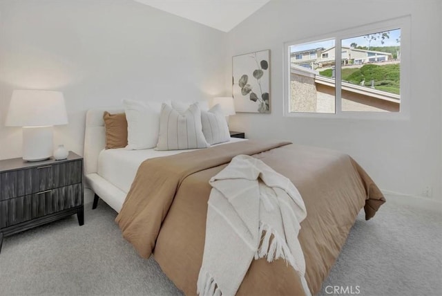 carpeted bedroom featuring lofted ceiling