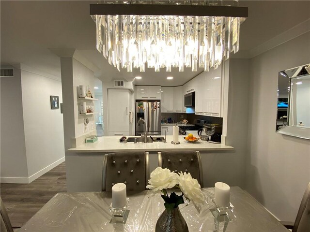 22272 Redwood Pointe Unit 5C, Lake Forest, CA 92630 - kitchen featuring stainless steel appliances, a sink, white cabinets, wood finished floors, and a peninsula