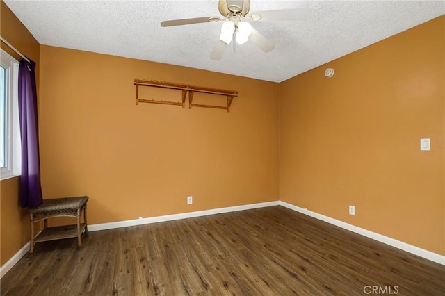 empty room featuring baseboards, a ceiling fan, dark wood-style floors, and a textured ceiling