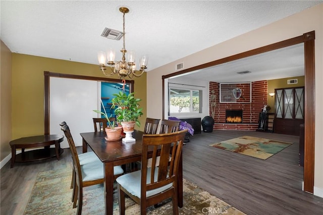 dining space with a notable chandelier, wood finished floors, and visible vents