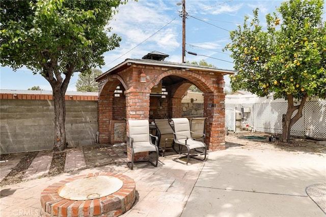 view of patio with a fenced backyard and a fireplace