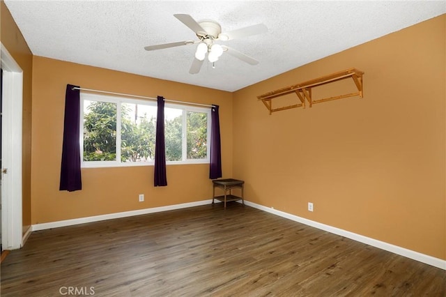 unfurnished room with baseboards, a textured ceiling, and wood finished floors