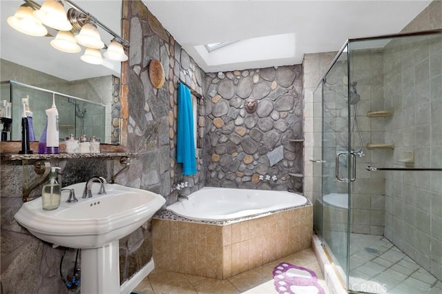 bathroom featuring a skylight, tile patterned floors, a bath, and a stall shower