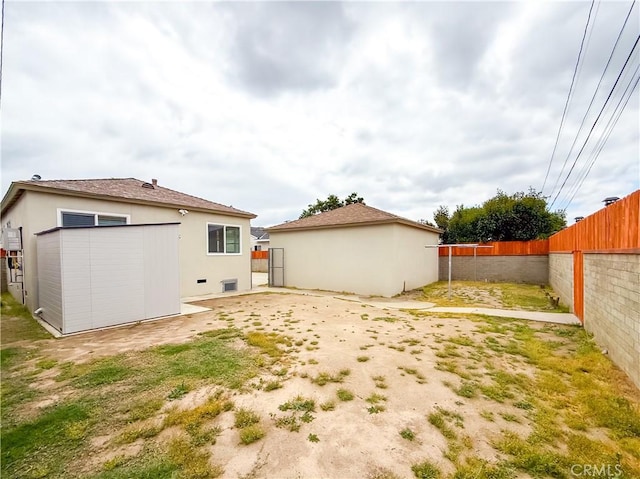 back of house featuring a fenced backyard and stucco siding