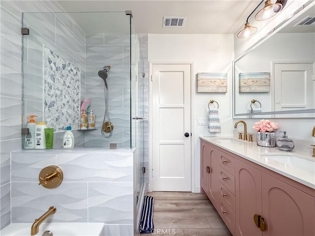 full bath featuring visible vents, a sink, and a tile shower