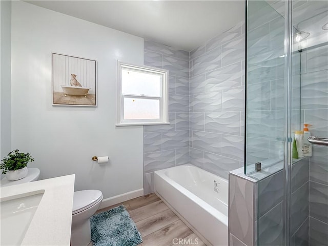 full bath featuring baseboards, a shower with door, wood finished floors, and toilet