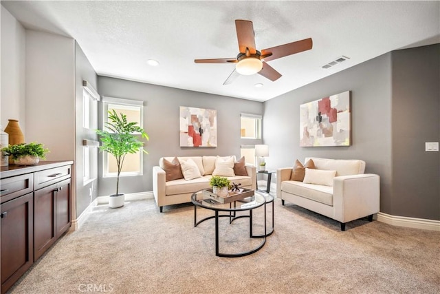 living area featuring baseboards, light colored carpet, ceiling fan, and recessed lighting