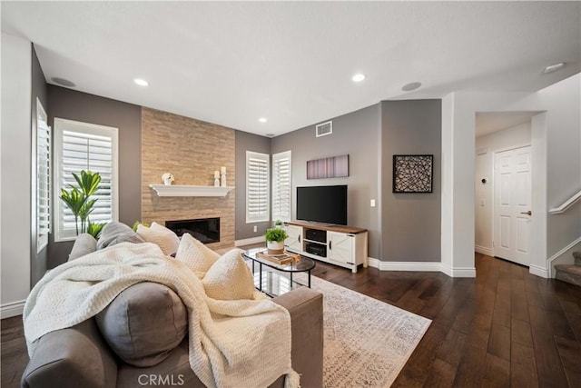 living area featuring baseboards, dark wood-style floors, a fireplace, recessed lighting, and stairway