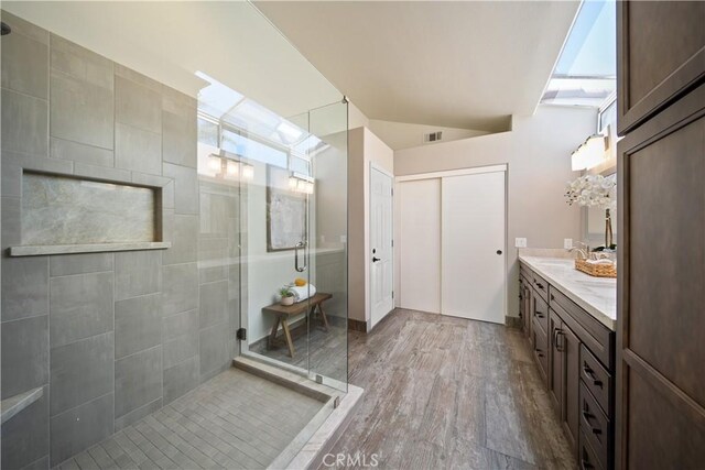 bathroom featuring a stall shower, wood finished floors, and vanity