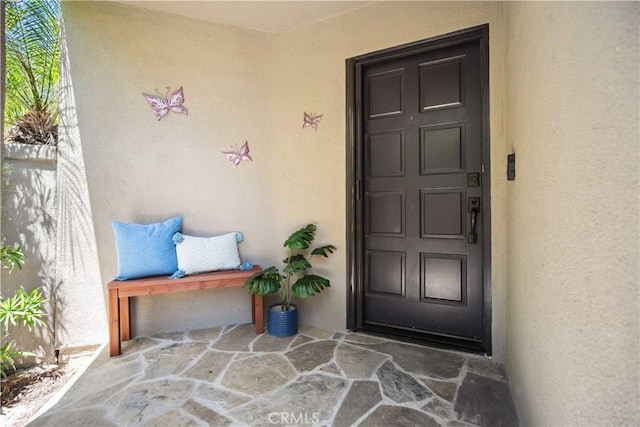 view of exterior entry with stucco siding